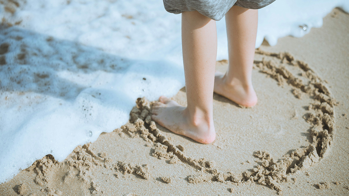 Child playing on beach representing healing and growth